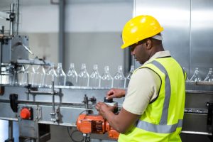 Food processing worker operating a bottle production machine, highlighting the skilled staffing recruitment services for food plants provided by Workvantage.