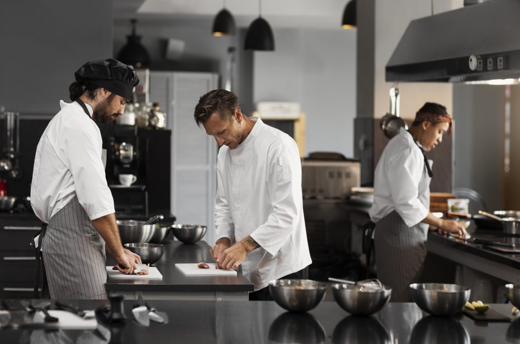chef-trabajando-juntos-cocina-profesional Chefs working in a modern kitchen, emphasizing Workvantage’s staffing solutions for the hospitality industry, ensuring qualified personnel for restaurants and culinary operations in Canada.