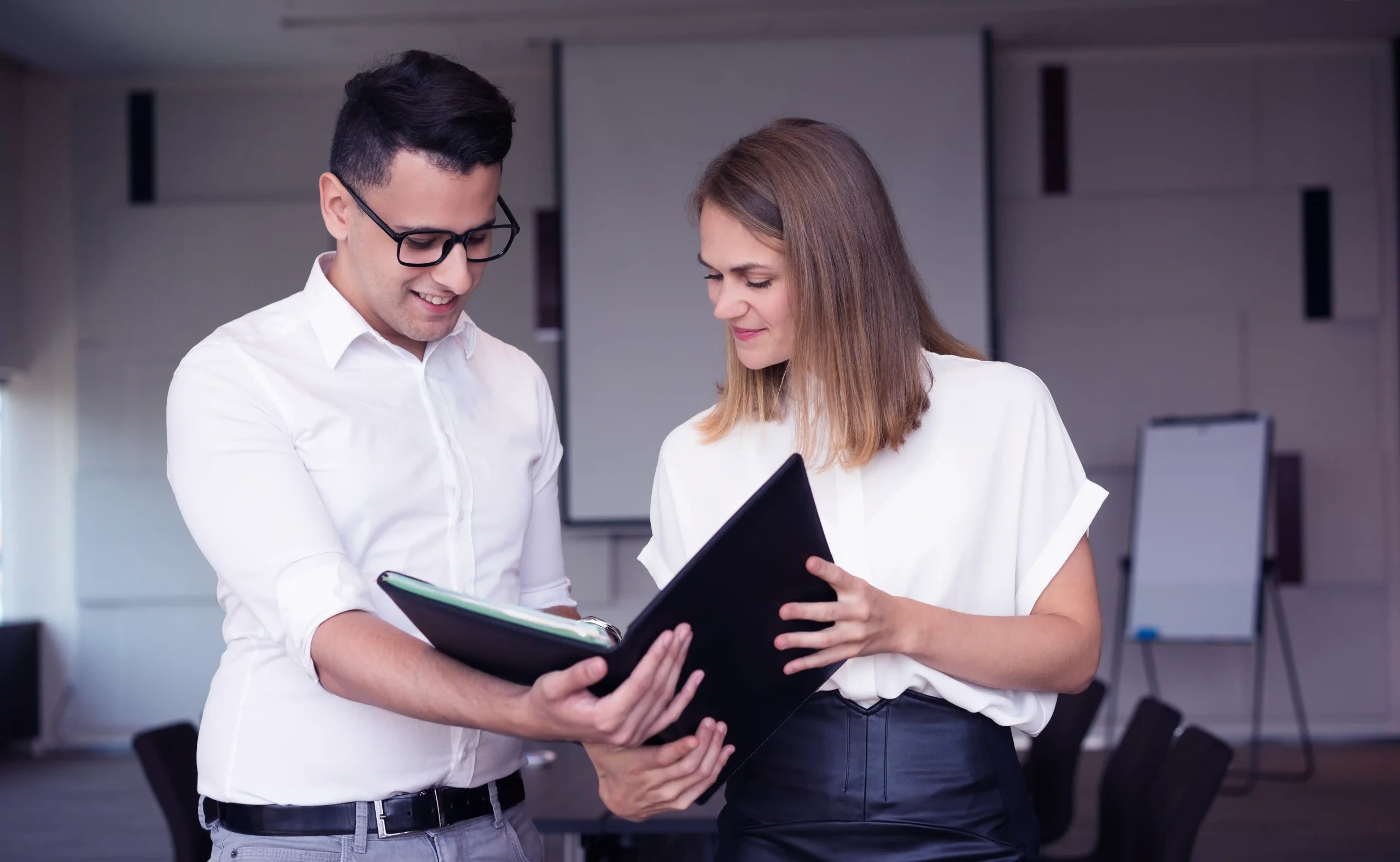 Two professionals reviewing documents, symbolizing Workvantage's support in guiding employers through the LMIA application and renewal process efficiently.
