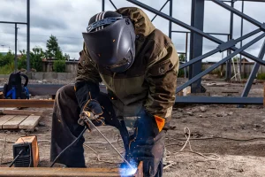 Industrial worker performing welding at a construction site. Workvantage offers skilled industrial workers and tradespeople to help companies in construction, manufacturing, and other industrial sectors meet their staffing needs.