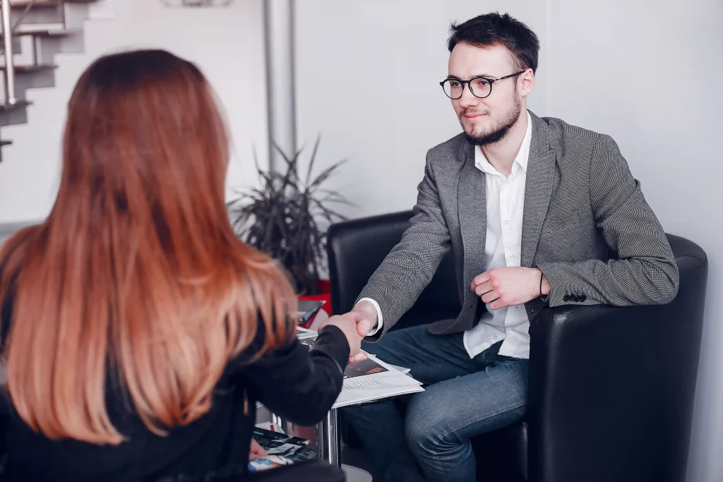 hundsome-businessmen-working-with-clients Employer shaking hands with a candidate during an interview, illustrating Workvantage's role in facilitating the LMIA application process for hiring qualified foreign workers.