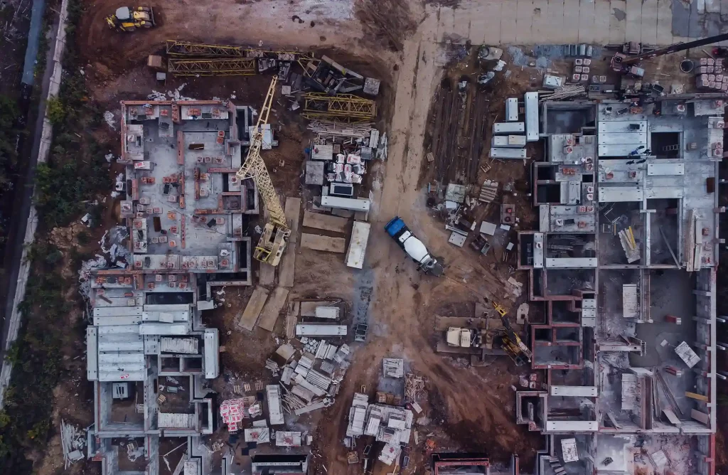 Vue aérienne d'un chantier de construction, symbolisant l'impact de l'urbanisation sur les terres arables et la nécessité de solutions durables.