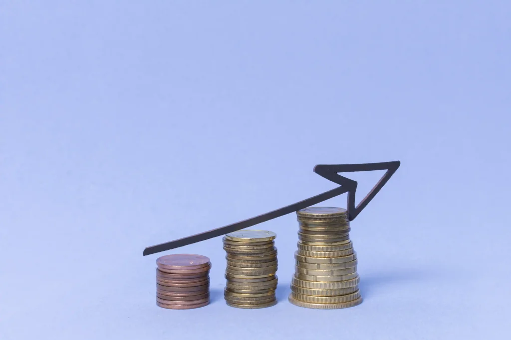 Graphique d'une pile de pièces de monnaie croissante avec une flèche ascendante, symbolisant la croissance des coûts ou des bénéfices liés au programme des travailleurs étrangers temporaires.