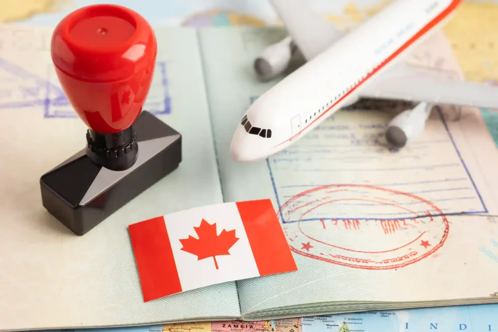 Passport with visa stamps, a miniature airplane, and the Canadian flag, reflecting Workvantage’s expertise in facilitating immigration processes for skilled workers.